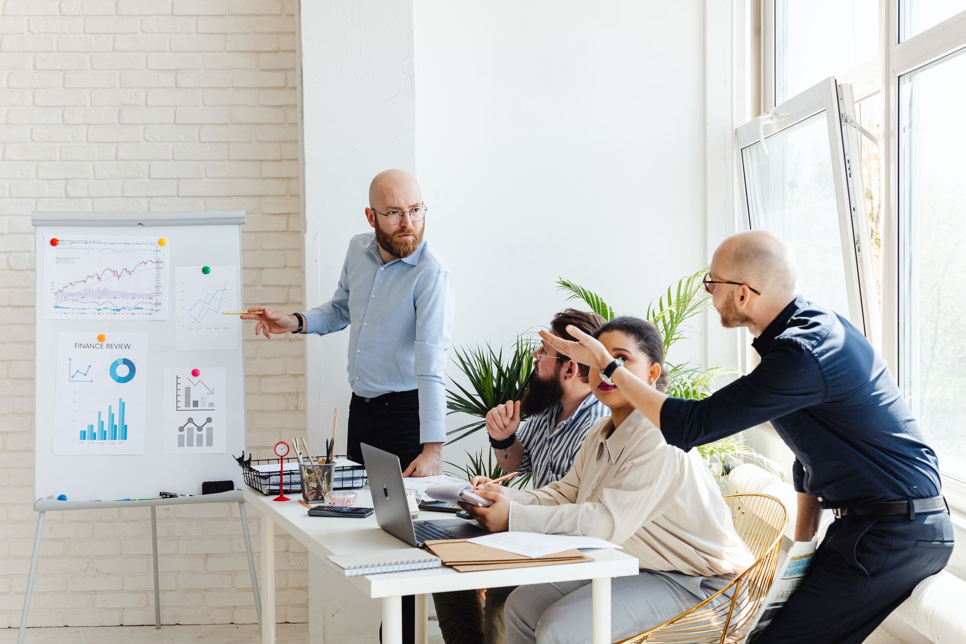 Professionals discussing financial charts at a whiteboard